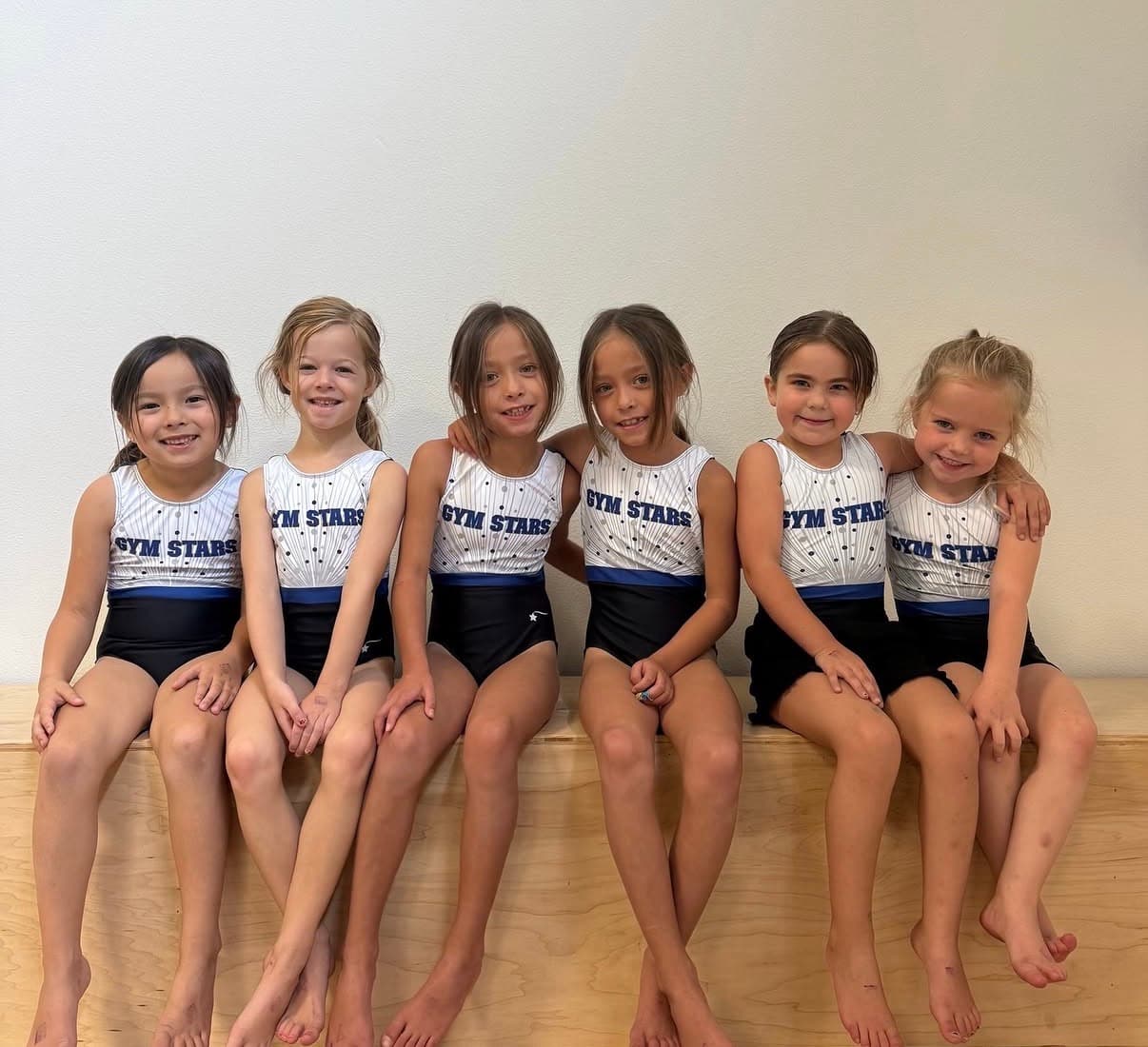 Gym Stars Developmental Team athletes sitting together in their team leotards