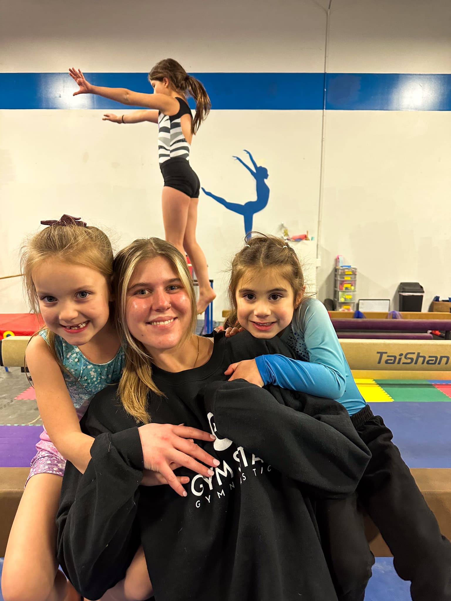 A Gym Stars coach with two young athletes
